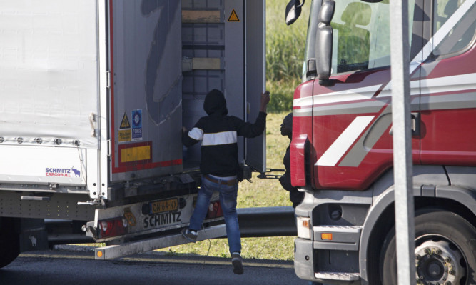 A migrant goes inside a lorry to attempt to cross the English Channel in Calais.