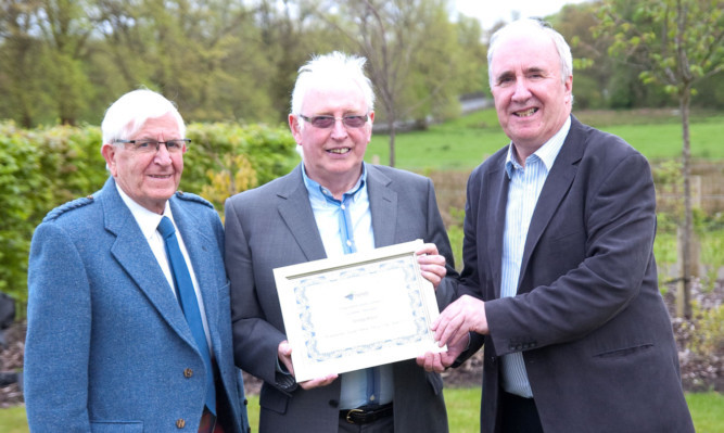 George Bruce (centre) is presented with the Hannah Stirling National Park award by friends vice-president George Boyd (left) and chairman James Fraser.