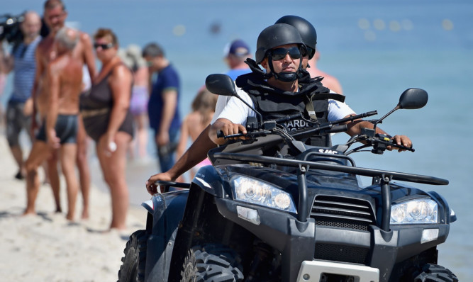 Armed guards patrol Marhaba beach during a visit by British Home Secretary Theresa May.