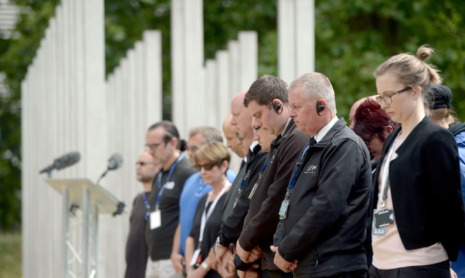 Security staff and workers from Hyde Park observe a minutes silence at the 7/7 memorial.