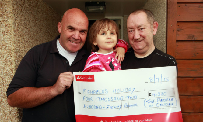 Charlie Kean, left, presents £4,280 raised through donations from the people of Dundee to Michaela and dad David.