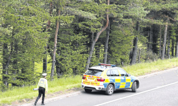 A police car near the site of the car crash which claimed the lives of John Yuill and Lamara Bell.