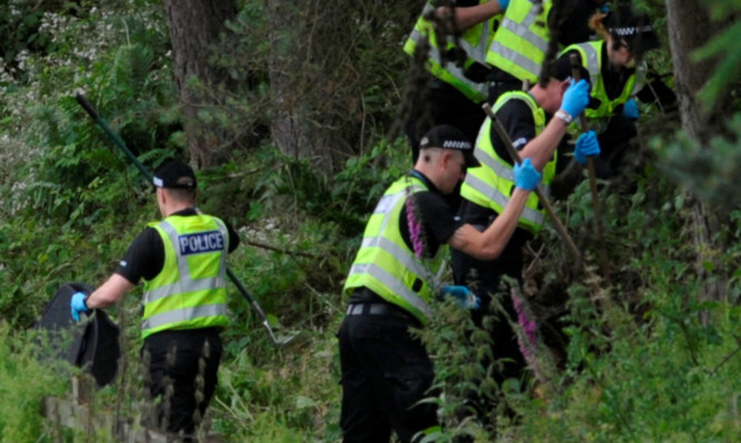 Police searching the verge where John Yuill and Lamara Bell were found after a three-day delay.