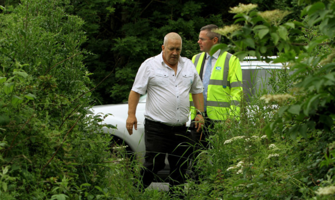 Logan Carries grandad Robert Brown shows Derek Mackay a path to the A92.