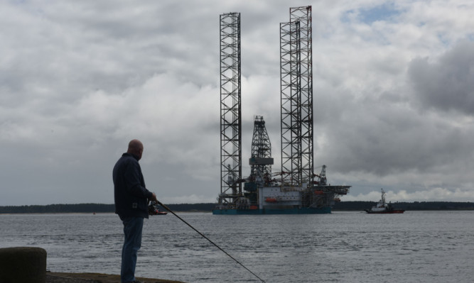 The Rowan Stavanger rig arriving in Dundee - watched by fisherman Tony Sutherland.