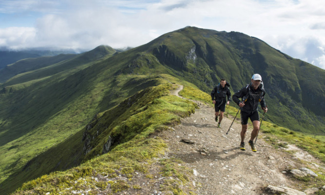 Team Honey-Stinger, participants of the 2015 Artemis Great Kindrochit Quadrathlon on route to their fifth Munro of the day with the summit of Ben Lawers in the distance.