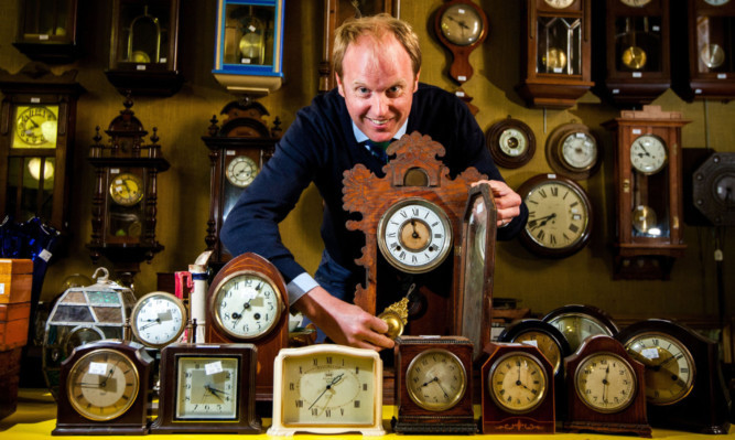 Auctioneer Nick Burnswith just some of the vast array of clocks for auction.