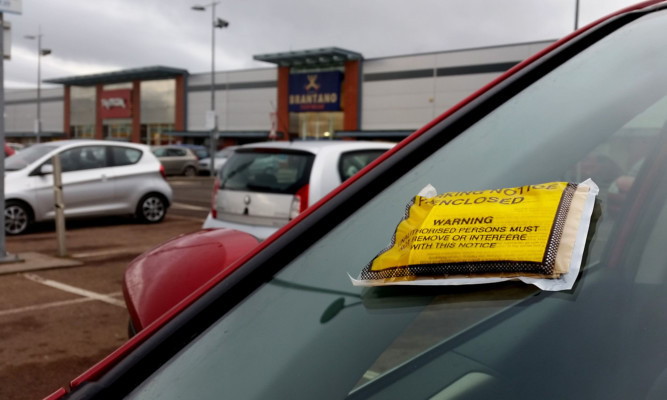 Kris Miller, Courier, 27/01/15. Picture today shows general view of a ticket on a car at UKPC car park at Gallacher Retail Park, Dundee for story about parking fines.