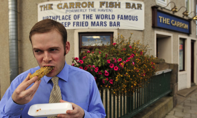 Courier reporter Rob McLaren trying a deep fried Mars Bar in 2012.