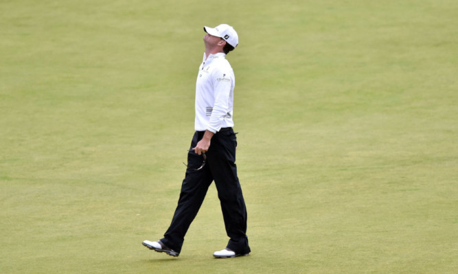 Zach Johnson watches Louis Oosthuizen's putt to extend the playoff miss on the 18th hole at St Andrews.