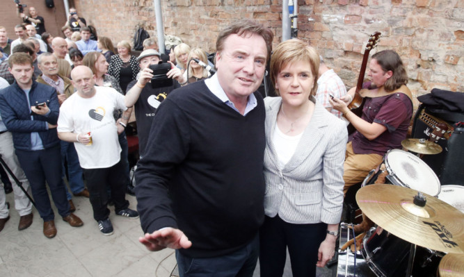 First Minister Nicola Sturgeon and Clutha Bar owner Alan Crossan in the Clutha Bar, Glasgow, as it reopens after a police helicopter crash in 2013, which killed 10 people.