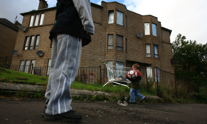 Two young boys play football in a street in Govan on September 30, 2008 in Glasgow, Scotland. Latest reports by the campaign to end child poverty, claim that millions of children are living in households living on under  £10 per person per day.