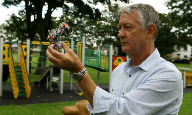 Cllr Tom Adams with a discarded drinks tin found in the playpark.