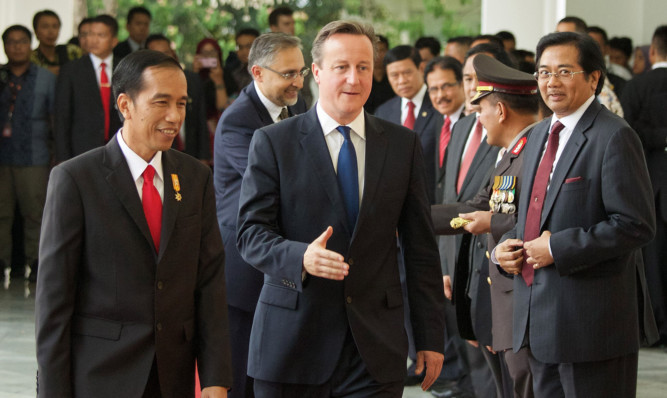 David Cameron, and Indonesian President Joko Widodo greet a group of Indonesian business and government leaders.