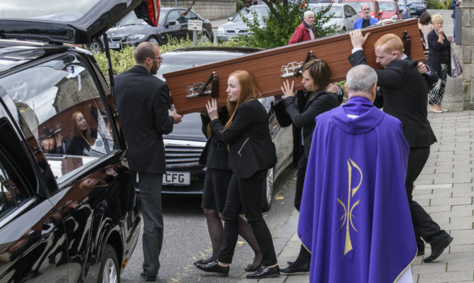 The coffin of John Yuill is carried to the hearse following his funeral at St Francis Xavier's RC Church in Falkirk.