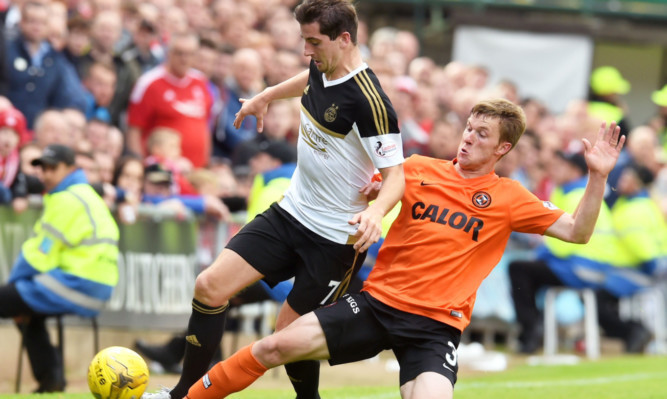 Paul Dixon challenges for the ball with Kenny Mclean (left)