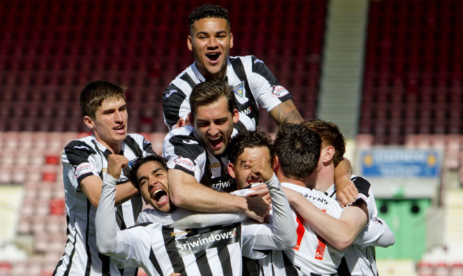 Faissal El Bahktaoui, front left, is mobbed by teammates after opening the scoring for the Pars.