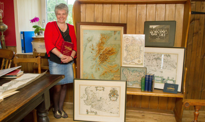 Glamis Book Fair organiser Hilary Farquharson with some of the maps and books up for sale at the event, which includes a photograph of Clepington Quoits Club, Forfarshire League Champions for 1910.