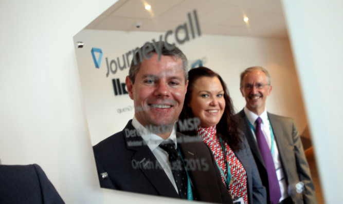 From left: Transport Minister Derek Mackay, Journeycall MD Theresa Wishart and Terry Dunn, CEO of ESP Group, reflected in a plaque to mark the opening.