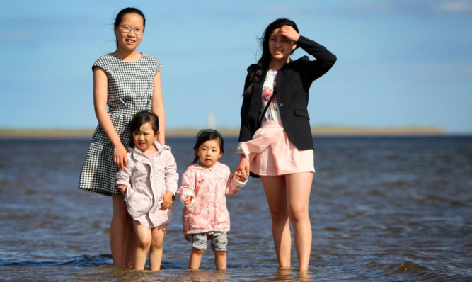 From left: Anne Weng, Claire Chen, Jannet He and Anna Jhou paddle in the water at Monifieth beach.