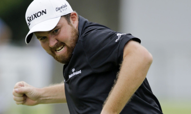 Shane Lowry pumps his fist as he watches his putt sink on the final hole to confirm victory.
