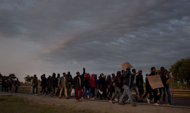 Migrants march toward the Channel Tunnel during a demonstration in Calais.