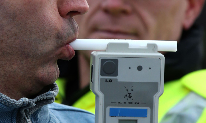 PICTURE POSED BY MODEL
Road Traffic constable John Parry from Police Scotland demonstrates breathalyser equipment at a drink-drive limit change awareness event at Lockerbie Police Station, Scotland, as the reduced drink-driving limit comes in to force at the end of this week.  ... Reduced drink drive limit ... 03-12-2014 ... Lockerbie ... UK ... Photo credit should read: Andrew Milligan/PA Wire. Unique Reference No. 21635129 ... Picture date: Wednesday December 3, 2014. The Scottish Parliament last month unanimously approved measures to reduce the legal limit from 80mg to 50mg per 100ml of blood with the change coming into force from Friday. See PA story SCOTLAND Alcohol. Photo credit should read: Andrew Milligan/PA Wire