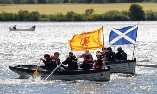 Participants in a boat race recalling Mary, Queen of Scots daring 1568 escape from imprisonment in Loch Leven Castle.