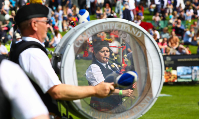 Comrie Pipe Band entertains spectators at Crieff Highland Gathering.