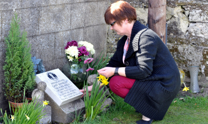 Catherine tends her son's grave.