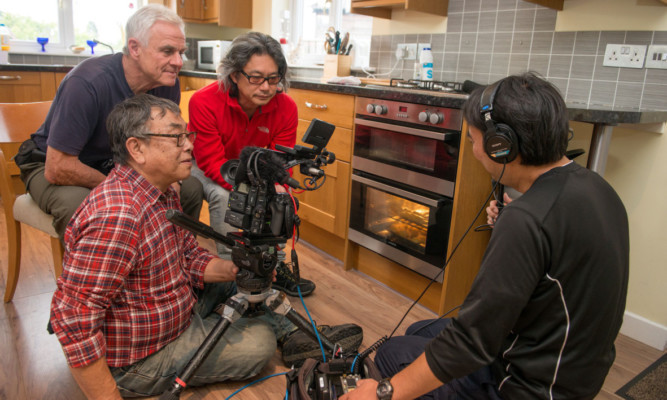 Director Nao Kubota, cameraman Koji Yoshida and soundman Kazumi Takahashi with location coordinator Jim Cuthbert filming a segment on the use of heather in cooking.