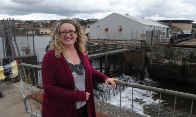 Chamber chief Alison Henderson beside the dock gate which needs to be repaired before the marina can be created.
