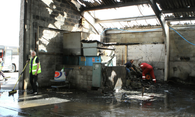 Staff clearing up after the fire at the bus companys premises on Mid Craigie Road.