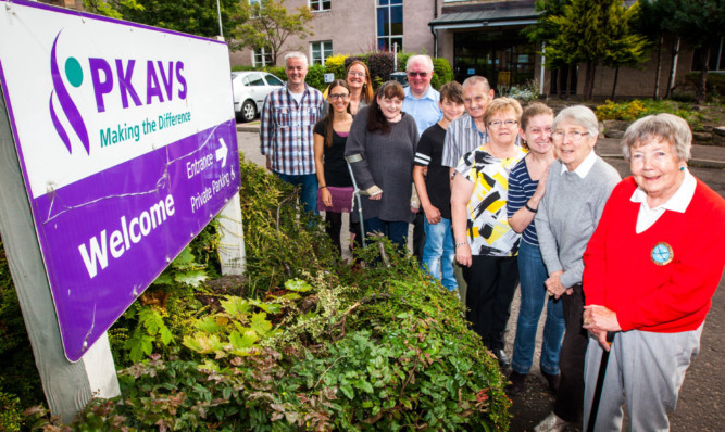 Token gesture: Raymond Jamieson, left, with service users and staff at the centre, says the charity would name the minibus after the person who collects the most tokens.