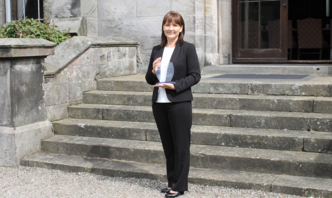 Detective Constable Gail Hill with the Ross Hunt Memorial Trophy for Outstanding Detective Trainee.