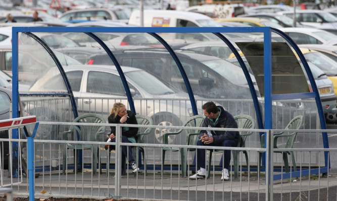 Smokers in a designated smoking shelter in hospital grounds.