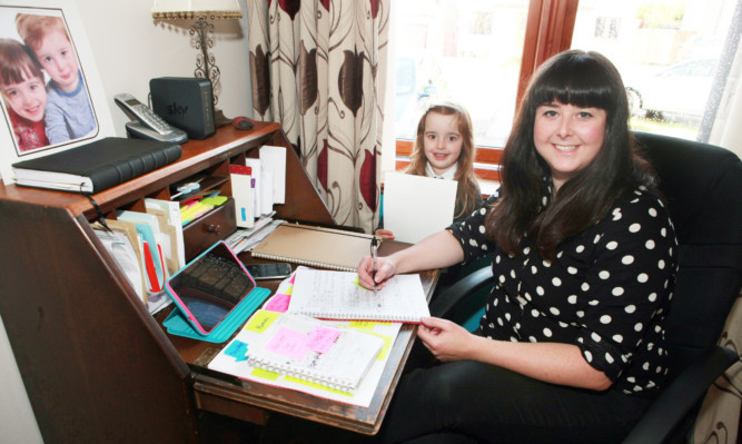 Jordan Butler catching up with some paperwork with help from five-year-old daughter Ella.