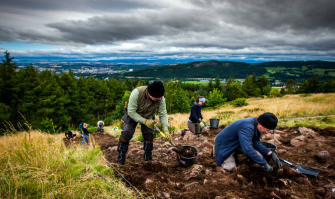 Volunteers Fraser Stewart, front, left, and Andrew Bain with Jess Lumb, centre, from AOC Archaeology. Perth and Kinnoull Hill can be seen in the background.