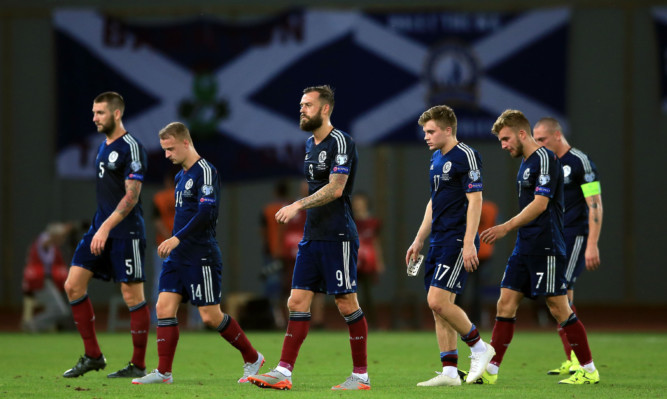 Scotland's players troop off after defeat.