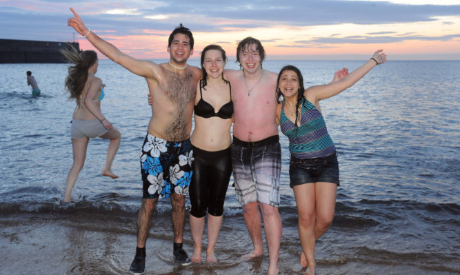 Students take part in the May Day dip on the East Sands in St Andrews as the sun comes up.