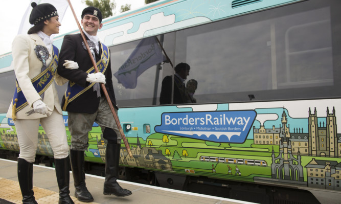 Braw Lad Cameron Pate and Braw Lass Abbie Franklin at the Tweedbank railway station to welcome a Borders Railway carriage