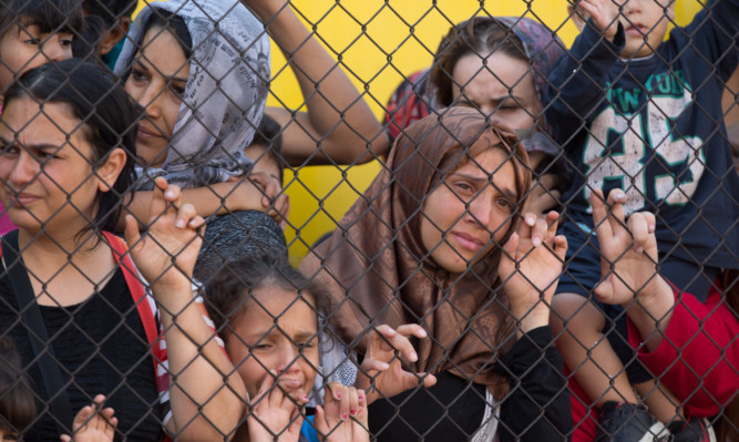 Migrants protest outside a train that they are refusing to leave for fear of being taken to a refugee camp  in Hungary.