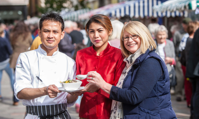 Thanan and Wanthana Sapsuri were at Perth Farmers Market on Saturday demonstrating Thai and Indian food, here sampled by visitor Helen Clayes.