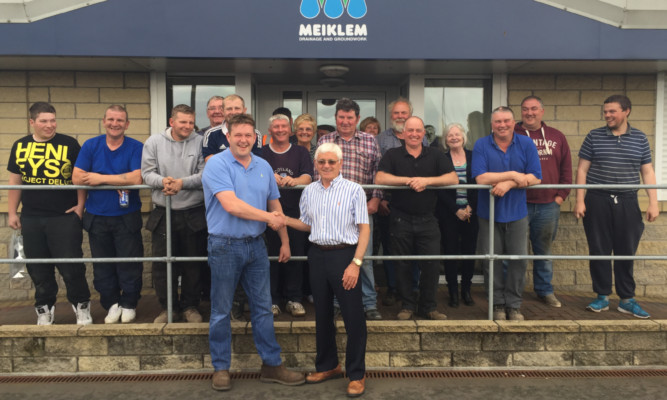 Sealing the deal: James Penman and John Meiklem with staff membersat Meiklems offices.