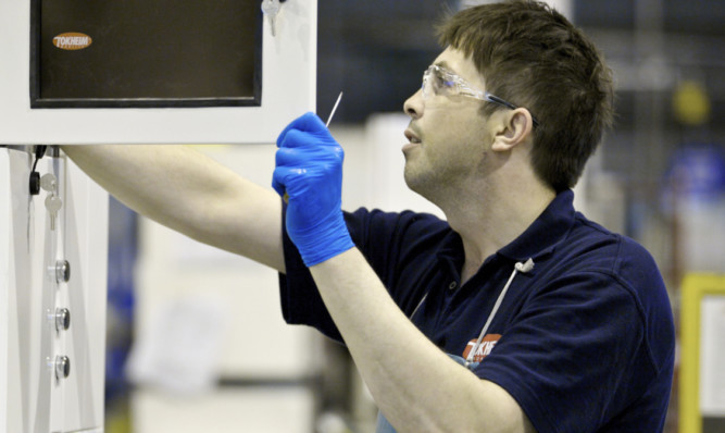 A technician checks a petrol pump assembly at Tokheims manufacturing facility in Dundee. Tokheim last night confirmed that all staff at Dundee would transfer to Dover as part of a $465m deal, and the factory would continue to operate as normal.