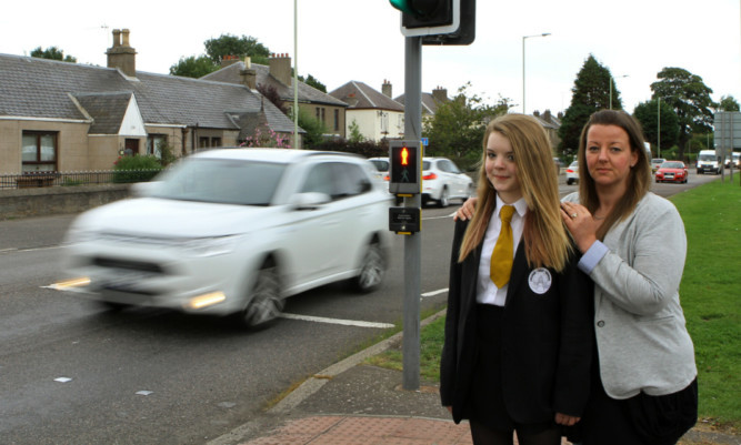 Regan and mum Stacey at the crossing where the frightening incident happened.