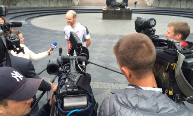 Gavin is greeted by members of the media at the finish line in St Petersburg.