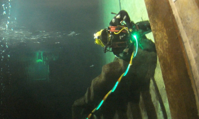 A subsea diver uses St Andrews-based Photosynergy Ltds Lightpath system.