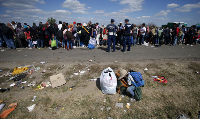 Migrants waiting for the bus which will take to the center for asylum seekers near Roszke in Hungary.