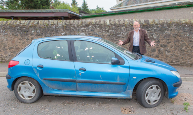 Tim Brett beside the problem car.